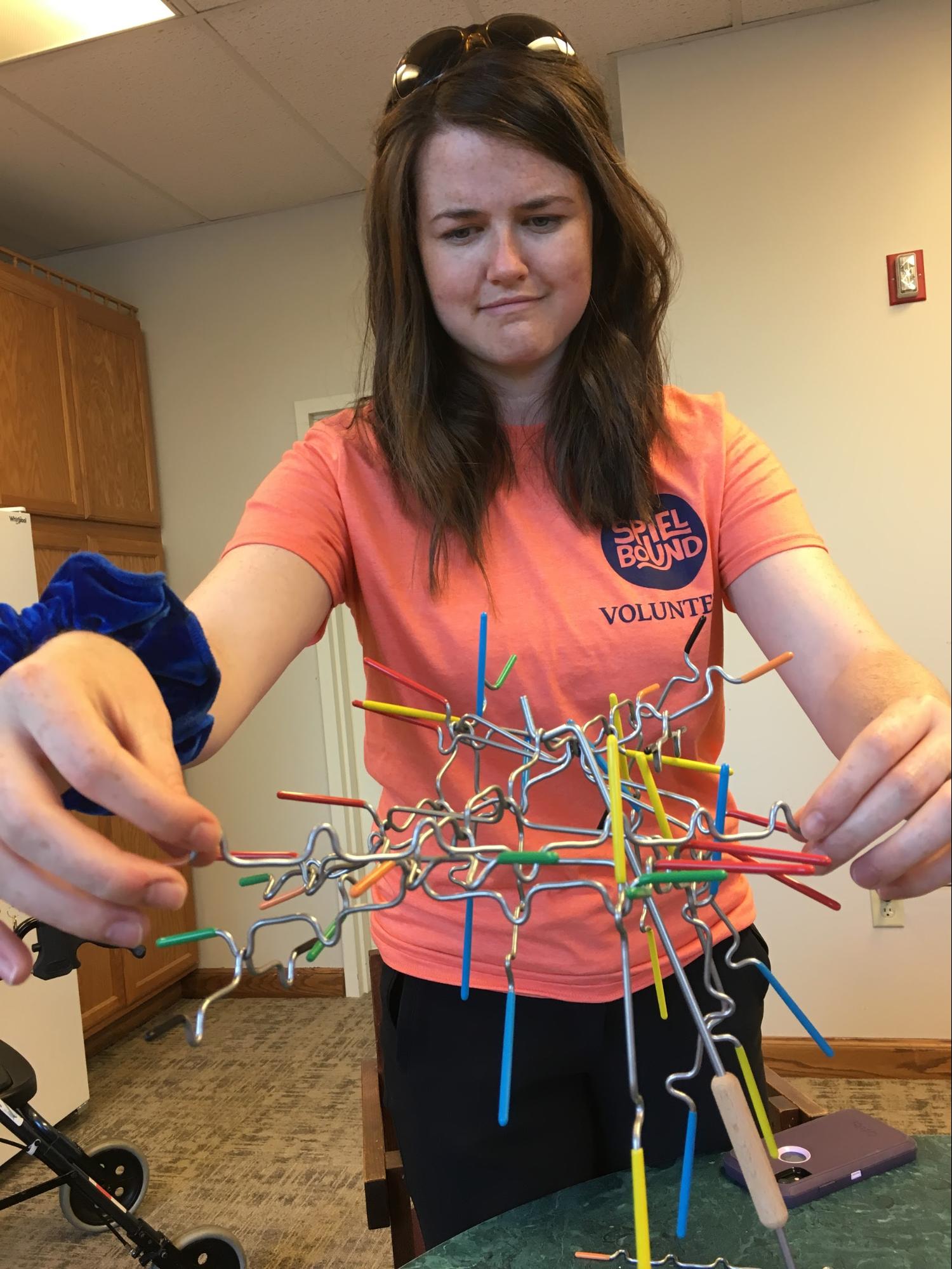 Stay Sharp's Sarah Foster attempts to balance a game piece while teaching suspend to participants at St. Joes Tower.